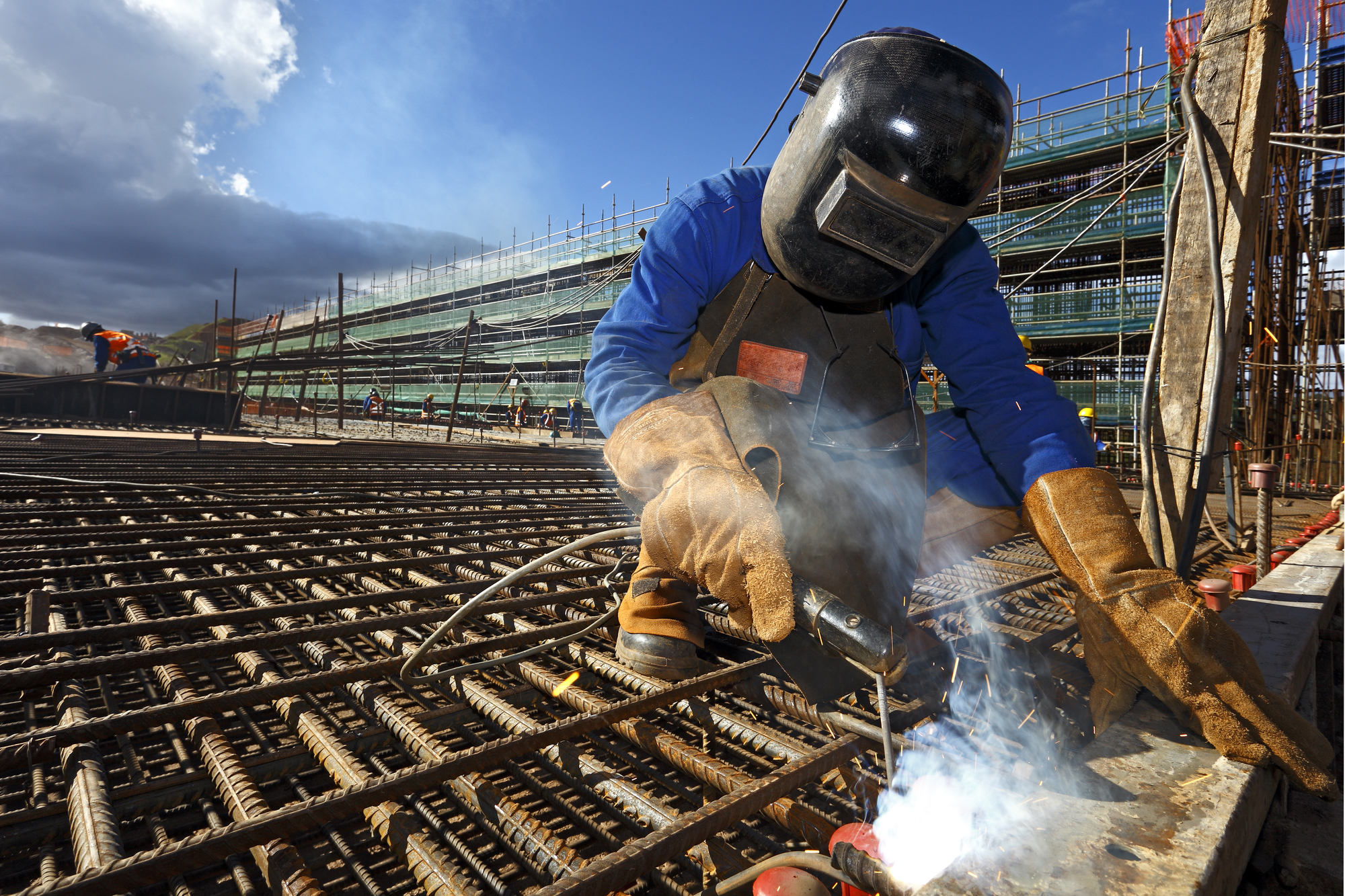 Welder Worker Welds Steel Bars